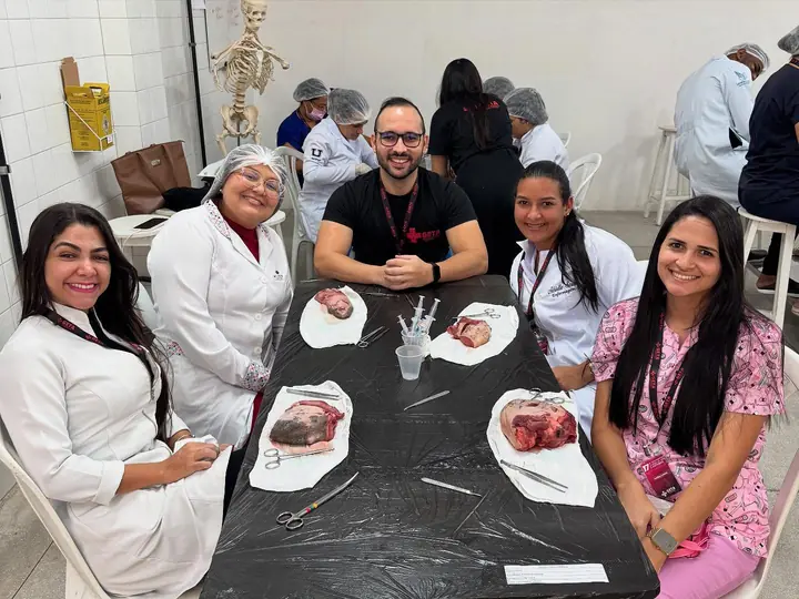 Alunos e instrutores em bancada de sutura