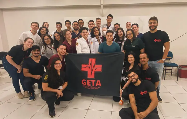 Turma do XII Curso de Nós e Suturas com a bandeira do GETA